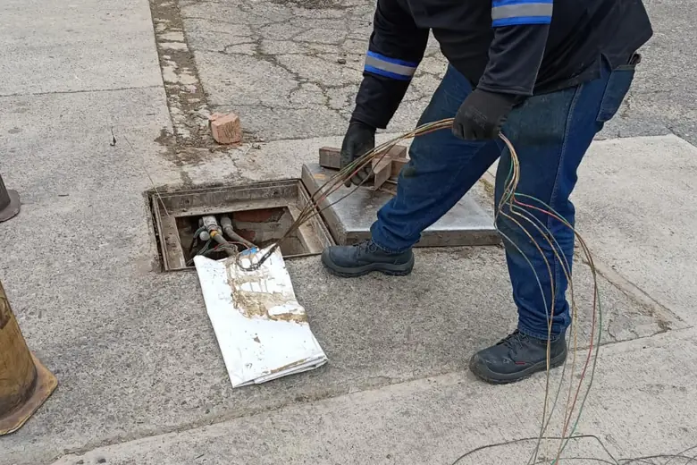 Técnico de ABALAR retirando cableado de una caja de registro en pista